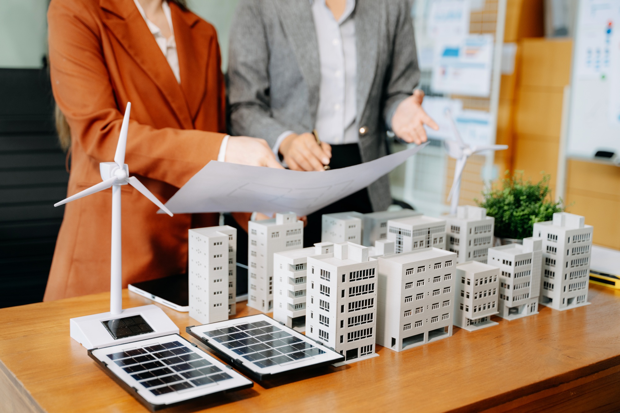 Asian architects and developers in a modern office collaborate using building models